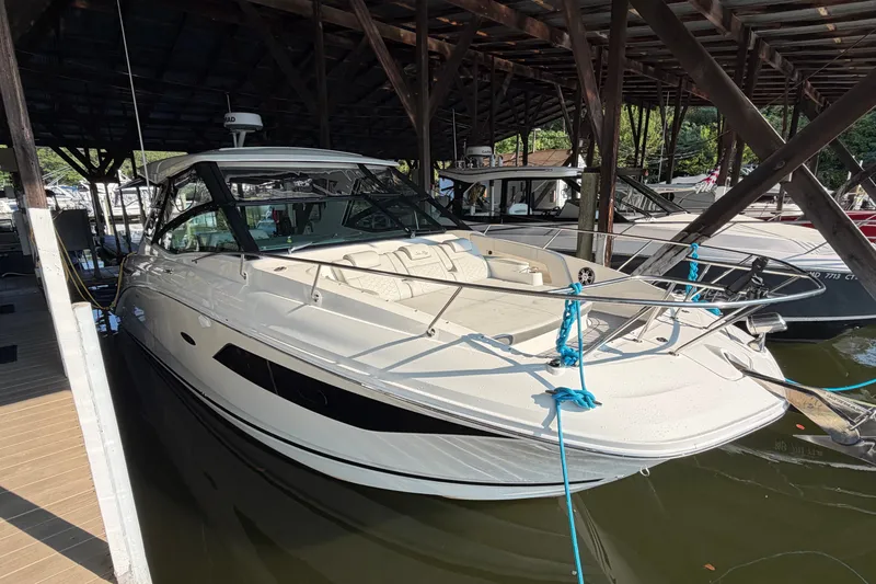 The Image of 2020 Sea Ray Sundancer 320 docked under a wooden canopy. - 0
