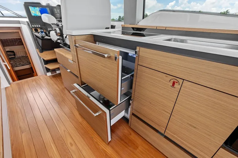 Slide: The Image of 2024 Tiara 48 LE yacht interior with wooden cabinetry and modern helm controls. - 40