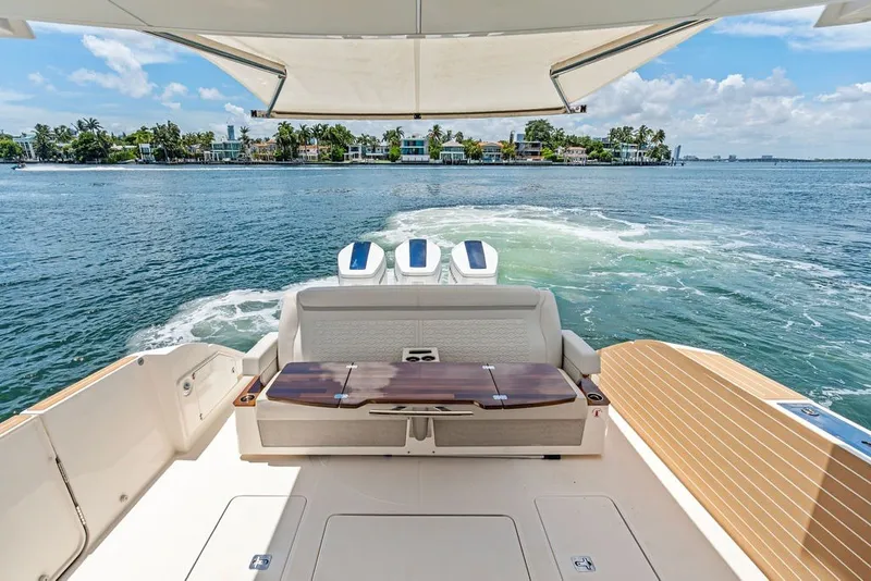 Slide: The Image of 2024 Tiara 48 LE yacht cruising on a sunny day, featuring luxurious seating and scenic waterfront views. - 33