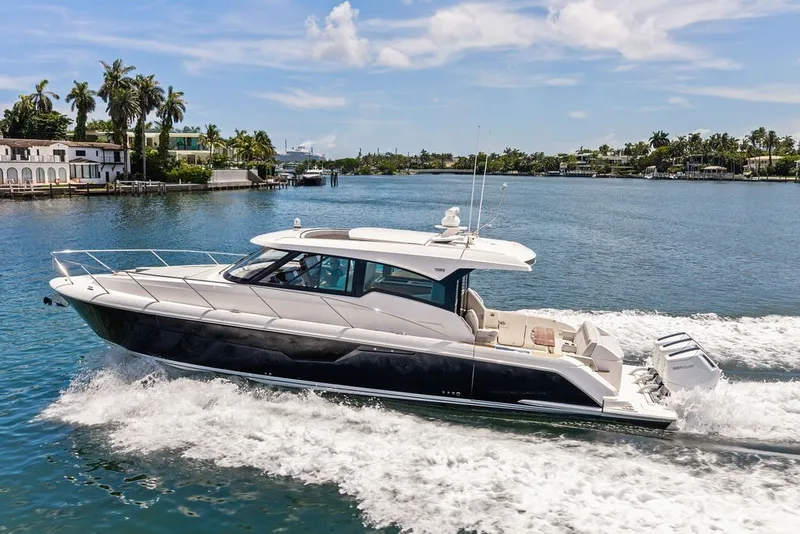 Slide: The Image of 2024 Tiara 48 LE luxury yacht cruising on a scenic waterway. - 13