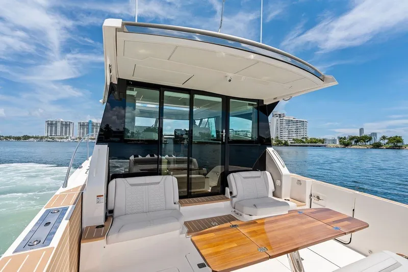 Slide: The Image of 2024 Tiara 48 LE yacht with luxurious seating and scenic waterfront view. - 30