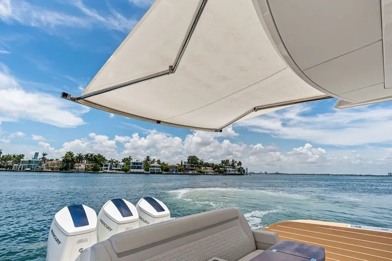 Slide: The Image of Luxury Tiara 48 LE 2024 yacht with canopy, cruising on a sunny day. - 32