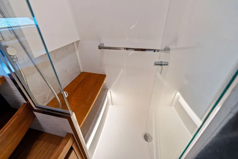 Slide: The Image of Luxurious shower area in 2024 Tiara 48 LE yacht with wooden bench and glass door. - 53