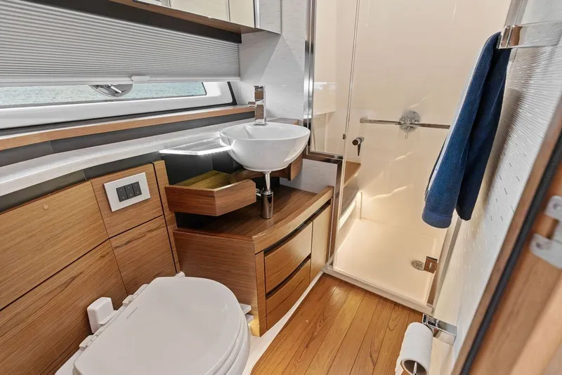 Slide: The Image of Luxurious 2024 Tiara 48 LE yacht bathroom with modern fixtures and wooden cabinetry. - 52