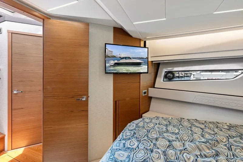 Slide: The Image of Luxurious 2024 Tiara 48 LE yacht interior with modern bedroom and TV display. - 50