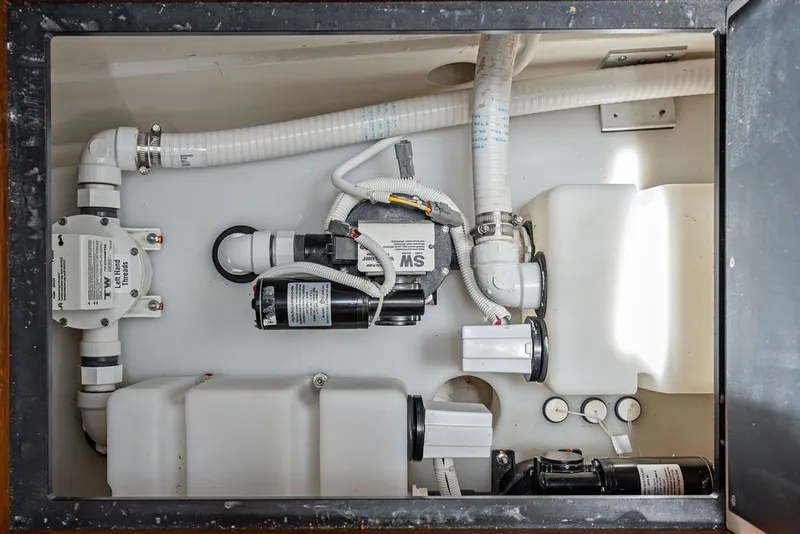 Slide: The Image of Engine compartment of 2024 Tiara 48 LE boat, showcasing plumbing and mechanical components. - 61