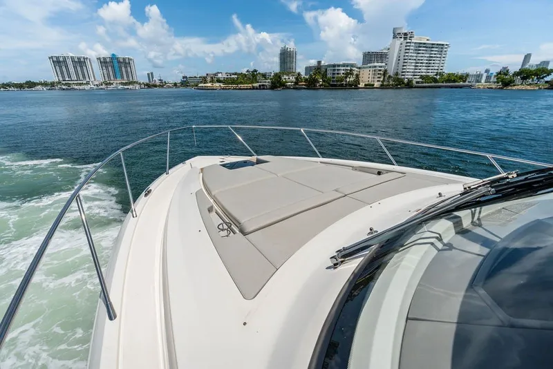 Slide: The Image of 2024 Tiara 48 LE yacht cruising near city skyline on a sunny day. - 15