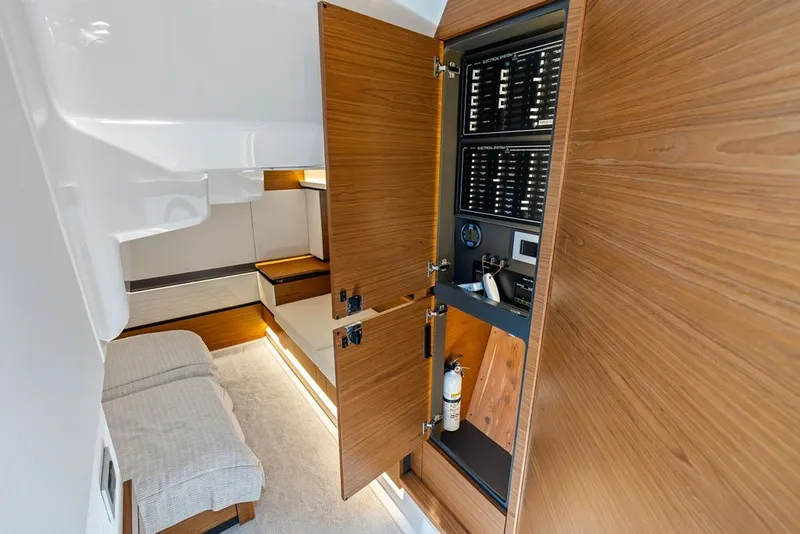 Slide: The Image of 2024 Tiara 48 LE yacht interior with wood paneling and electrical control panel. - 60