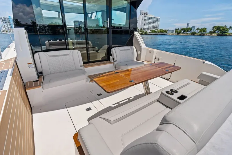 Slide: The Image of Luxurious 2024 Tiara 48 LE yacht deck with elegant seating and wooden table, overlooking serene waters. - 29