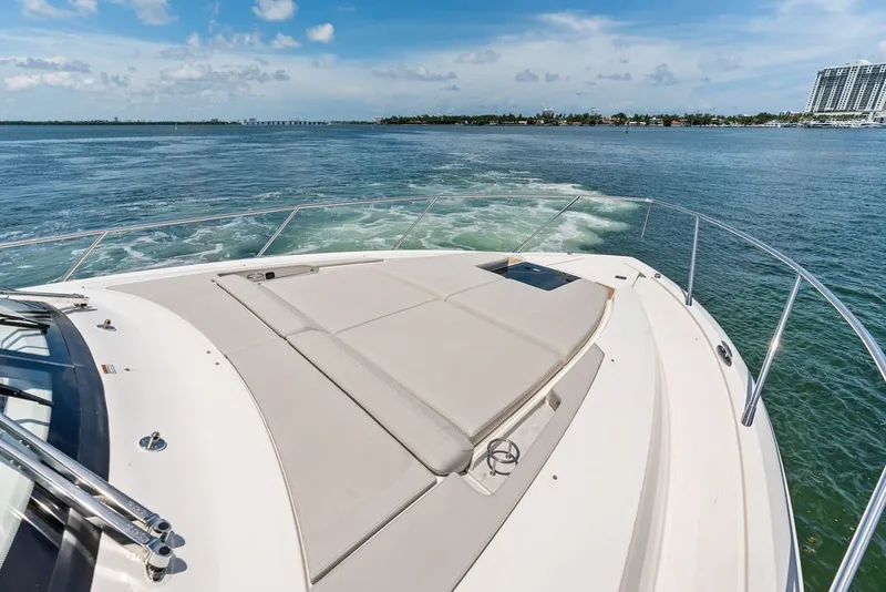 Slide: The Image of 2024 Tiara 48 LE yacht cruising on a sunny day with scenic ocean view. - 17