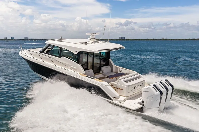 Slide: The Image of 2024 Tiara 48 LE yacht cruising on open water, showcasing sleek design and powerful engines. - 14