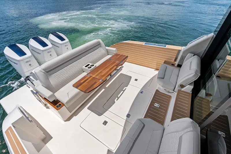 Slide: The Image of Luxurious 2024 Tiara 48 LE yacht deck with seating and triple Mercury outboard engines. - 22