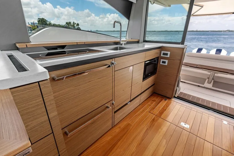 Slide: The Image of Luxurious 2024 Tiara 48 LE yacht kitchen with modern wood cabinetry and ocean view. - 38