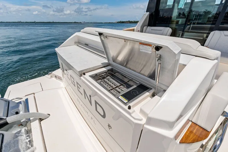 Slide: The Image of 2024 Tiara 48 LE yacht with outdoor grill, ocean backdrop, and luxurious seating. - 23