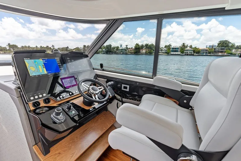Slide: The Image of Helm of 2024 Tiara 48 LE yacht with advanced navigation systems and luxurious seating. - 44