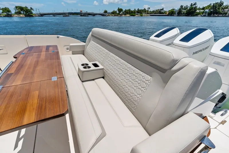 Slide: The Image of Luxurious seating and table on 2024 Tiara 48 LE boat, with scenic water view. - 25