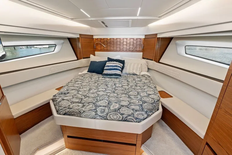 Slide: The Image of Luxurious 2024 Tiara 48 LE yacht cabin with elegant bedding and modern wood accents. - 48