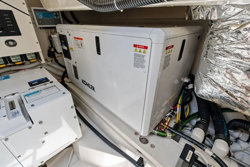 Slide: The Image of Engine room of 2024 Tiara 48 LE yacht featuring Kohler generator and wiring. - 65