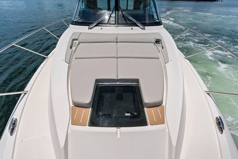 Slide: The Image of 2024 Tiara 48 LE yacht bow with cushioned seating and sleek design on open water. - 16