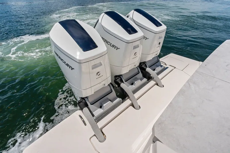 Slide: The Image of Triple Mercury outboard engines on 2024 Tiara 48 LE boat, cruising on open water. - 21