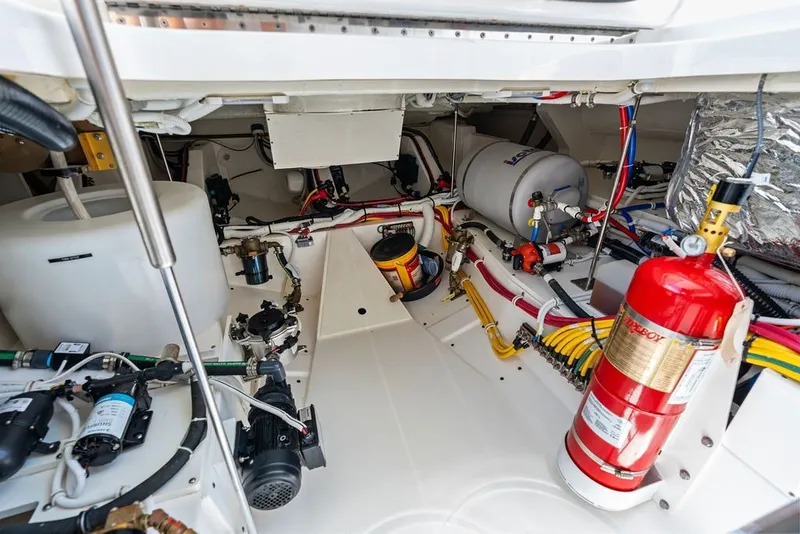 Slide: The Image of Engine room of 2024 Tiara 48 LE yacht, featuring equipment and fire extinguisher. - 63