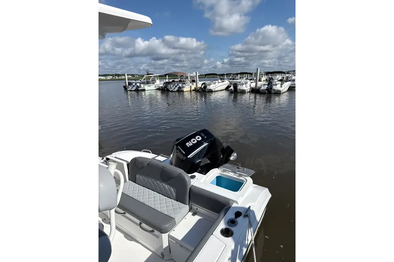 Slide: The Image of 2024 NauticStar 222L Offshore boat docked at marina under blue sky. - 6