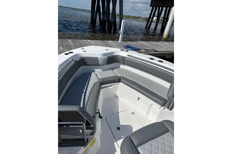 The Image of 2024 NauticStar 222L Offshore boat with spacious seating, docked by the water. - 1
