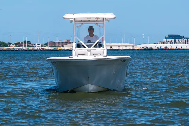 Slide: The Image of 2022 Sea Fox 248 Commander boat cruising on calm waters near an urban shoreline. - 2