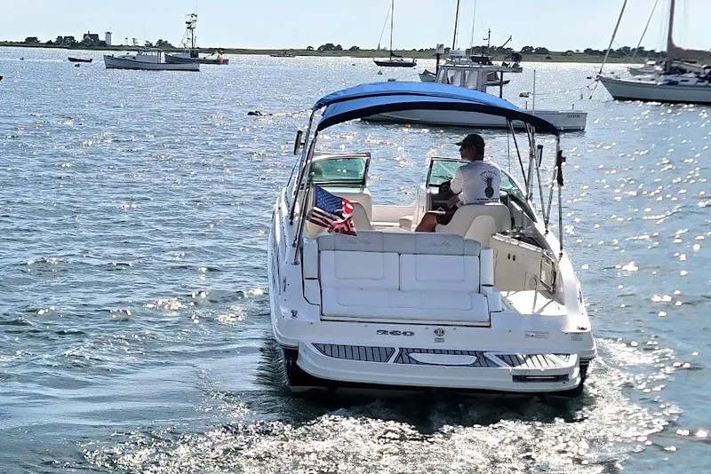 Slide: The Image of 2012 Sea Ray 260 Sundeck boat cruising on a sunny day with American flag. - 40