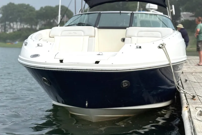 Slide: The Image of A 2012 Sea Ray 260 Sundeck docked. It features a sleek white and blue design. - 37