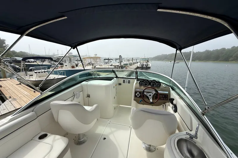 Slide: The Image of 2012 Sea Ray 260 Sundeck interior with helm, seats, and marina view. - 38