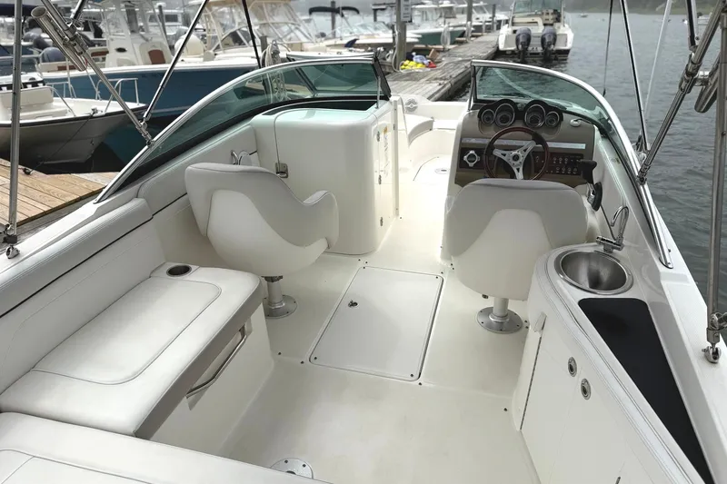 Slide: The Image of 2012 Sea Ray 260 Sundeck interior with helm, seating, and sink, docked at marina. - 26