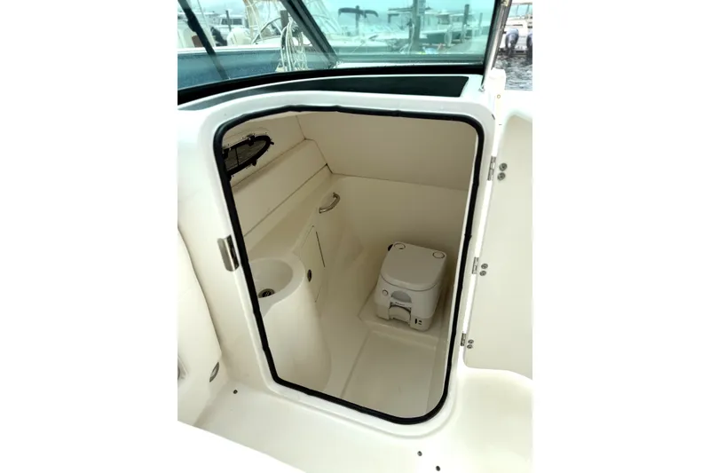 Slide: The Image of 2012 Sea Ray 260 Sundeck boat interior with compact marine toilet. - 18