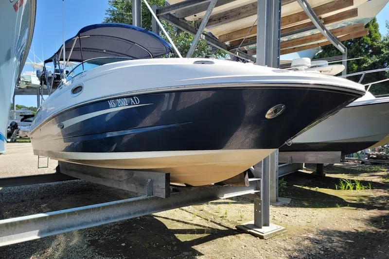 Slide: The Image of 2012 Sea Ray 260 Sundeck boat on a storage rack, blue and white exterior. - 21