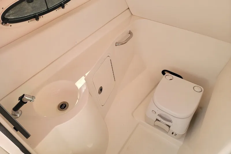 Slide: The Image of Interior of 2012 Sea Ray 260 Sundeck boat bathroom with sink and portable toilet. - 10