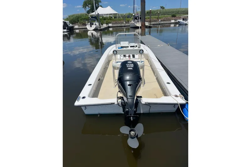 Slide: The Image of 2006 Twin Vee 19 BayCat boat docked, featuring an outboard motor and spacious interior. - 4