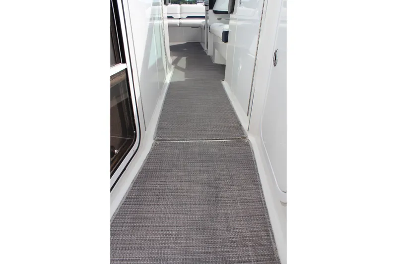 Slide: The Image of 2017 Formula 330 Crossover Bowrider interior walkway with gray carpet flooring. - 15