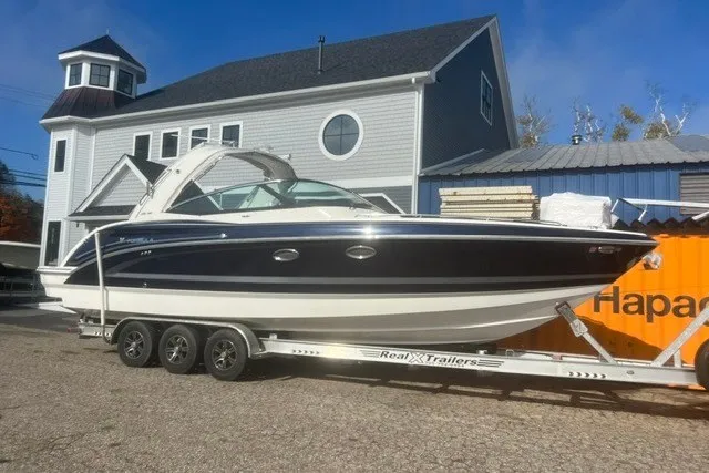 Slide: The Image of 2017 Formula 330 Crossover Bowrider on trailer, parked near a house and shipping container. - 44