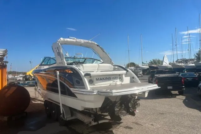 Slide: The Image of 2017 Formula 330 Crossover Bowrider boat on trailer in sunny marina setting. - 46