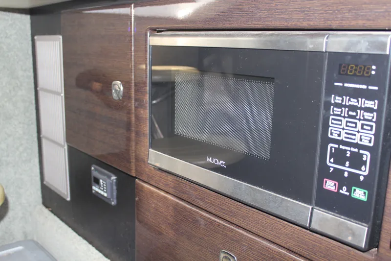 Slide: The Image of 2017 Formula 330 Crossover Bowrider interior with built-in microwave and wood paneling. - 39
