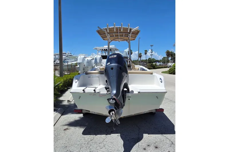 Slide: The Image of 2016 Sportsman Heritage 211 Center Console boat with outboard motor, parked on sunny day. - 4