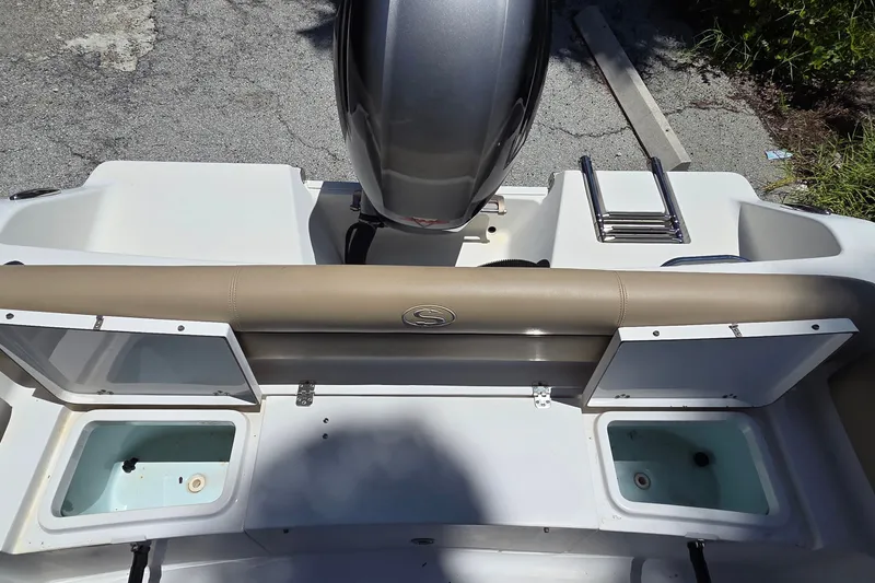 Slide: The Image of 2016 Sportsman Heritage 211 Center Console boat with open storage compartments and motor. - 7