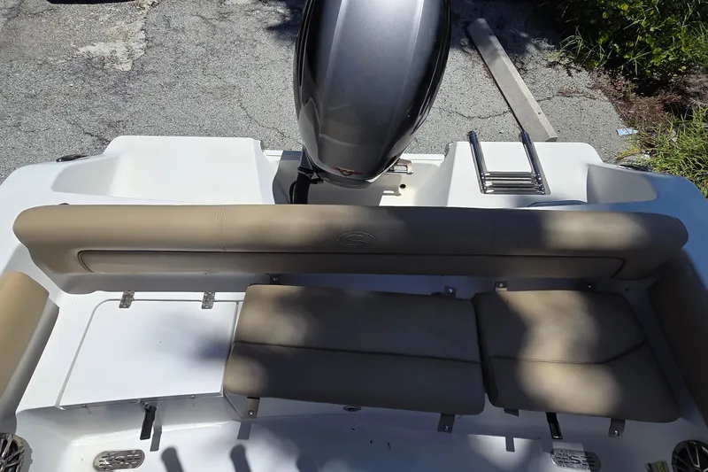 Slide: The Image of 2016 Sportsman Heritage 211 Center Console boat with cushioned seating and outboard motor. - 15