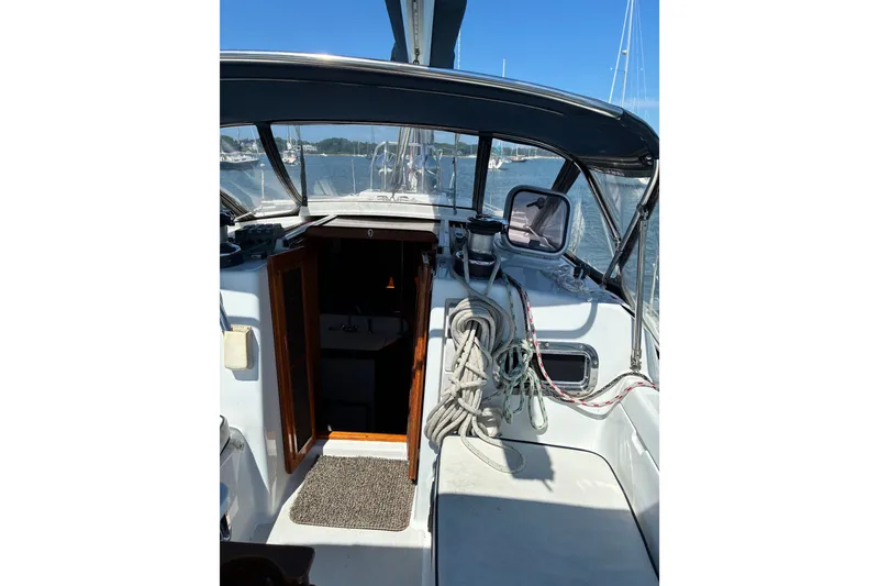 Slide: The Image of 1996 Freedom 35 sailboat cockpit with ropes, open cabin door, and marina view. - 24