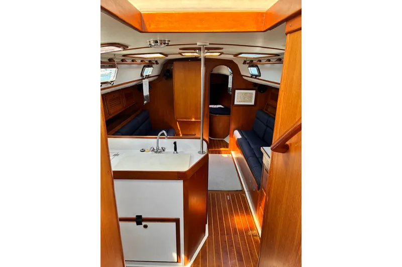 Slide: The Image of Interior of 1996 Freedom 35 sailboat with wooden finish and cozy seating area. - 15