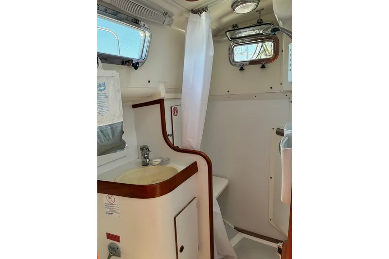 Slide: The Image of 1996 Freedom 35 yacht bathroom with sink, shower, and porthole windows. - 8