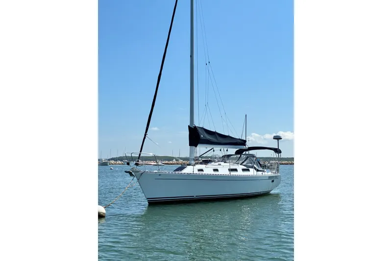 Slide: The Image of Sailboat Freedom 35, 1996 model, anchored in calm waters under a clear blue sky. - 33