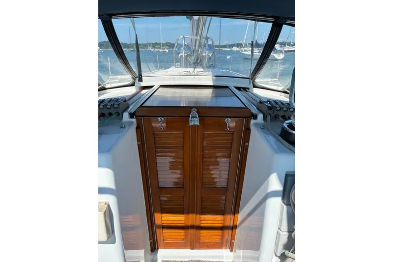 Slide: The Image of Cockpit view of a 1996 Freedom 35 sailboat with wooden hatch and marina background. - 11