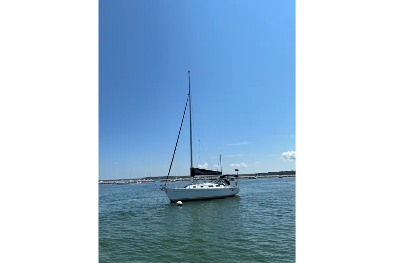 Slide: The Image of Sailboat "Freedom 35" from 1996 on calm waters under clear blue sky. - 18