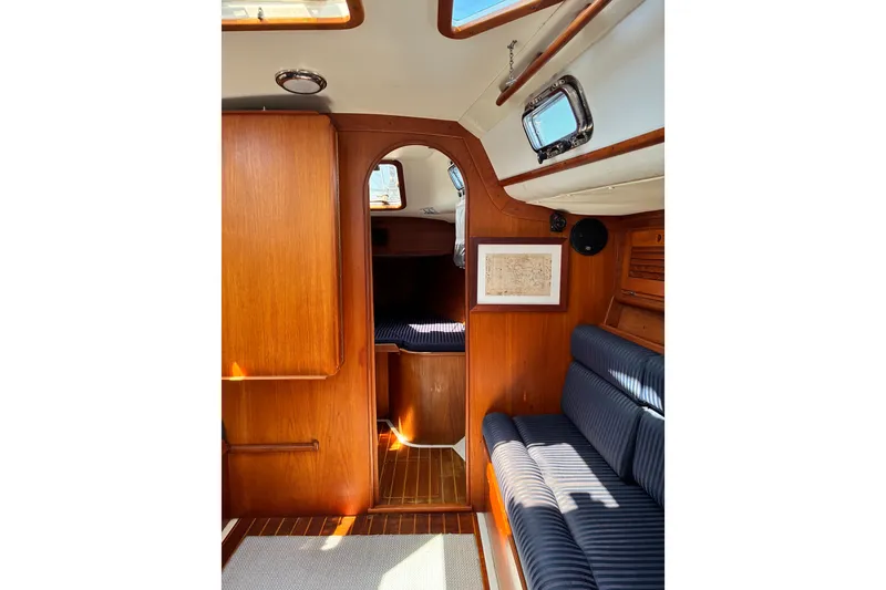 Slide: The Image of Interior of 1996 Freedom 35 sailboat with wooden finish and cozy seating area. - 9